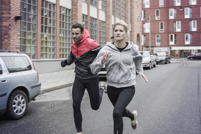 Sporty couple running on street