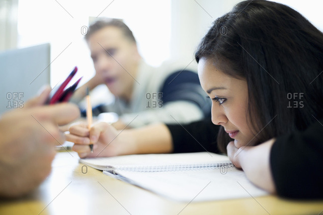 Female student studying with friends in common room at college