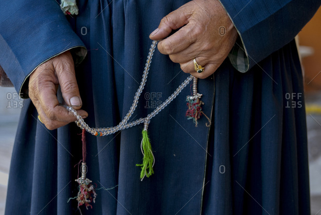 Person's hands holding prayer beads