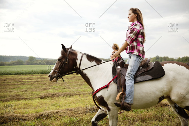 Young women horse riding at a field