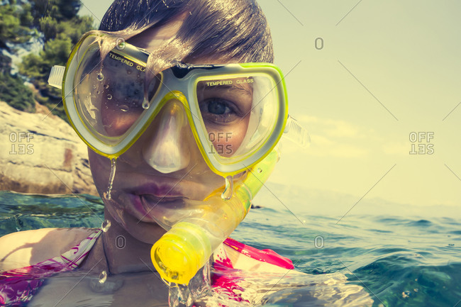 Teenage girl in water with diving goggles and snorkel