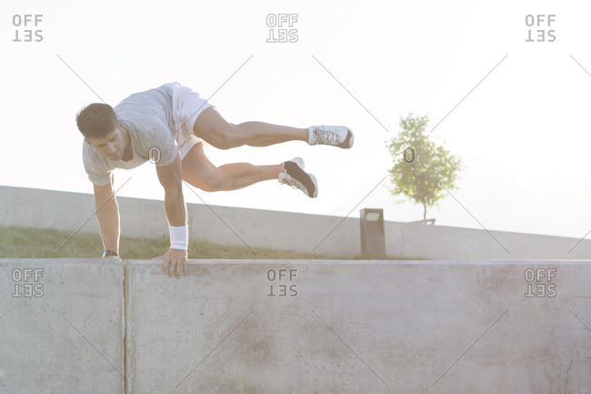 Young man jumping over wall