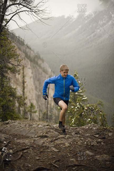 Athletic young man running up a steep slope