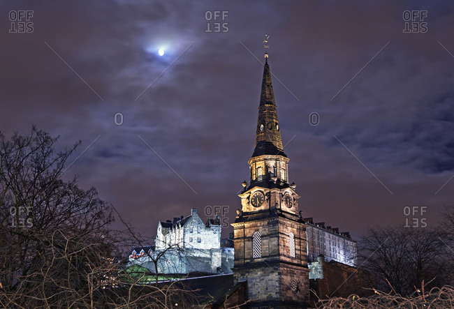 Spire of St Cuthbert's Church and Edinburgh Castle at night with full moon, Edinburgh, Scotland