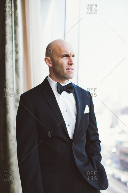 Portrait of groom looking at the window