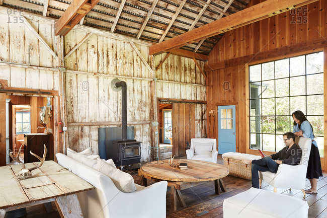 Couple in country chic style living room in barn
