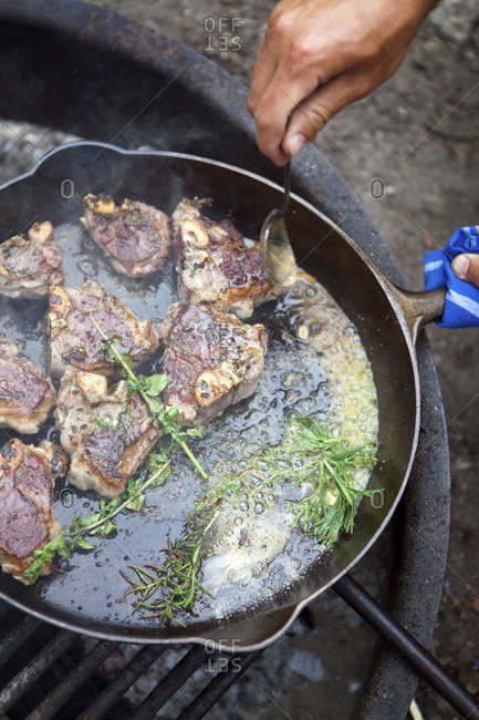 Lamb chops are seared with fresh rosemary and butter on grill