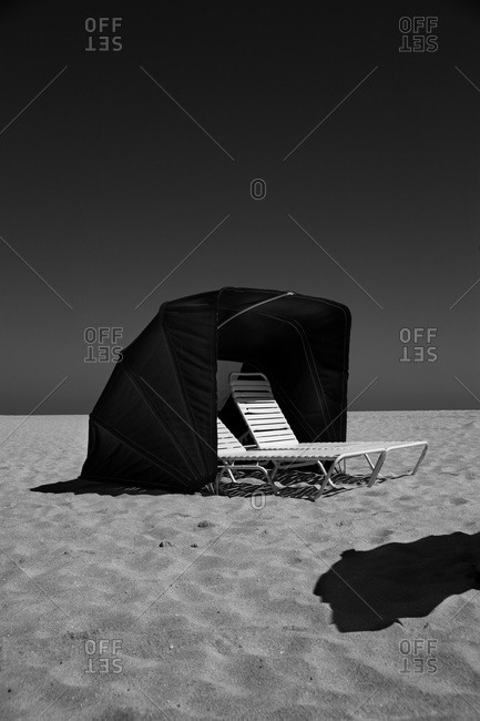 Beach tent with two chairs on seashore