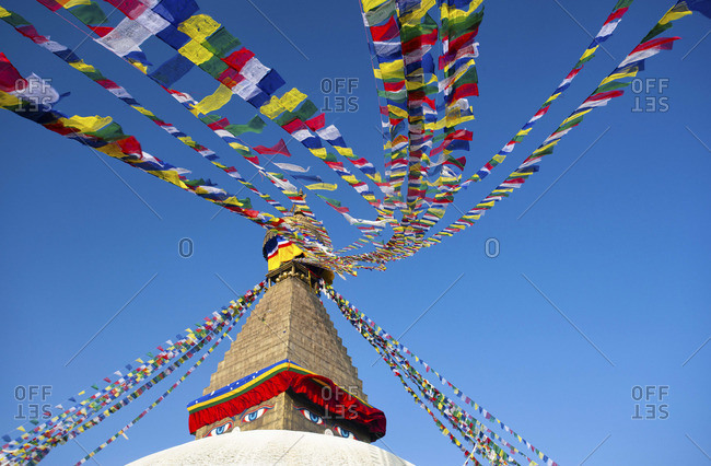 Bodhnath Stupa (Boudhanth) (Boudha), one of the holiest Buddhist sites in Kathmandu, UNESCO World Heritage Site, with colorful prayer flags against clear blue sky, Kathmandu, Nepal, Asia