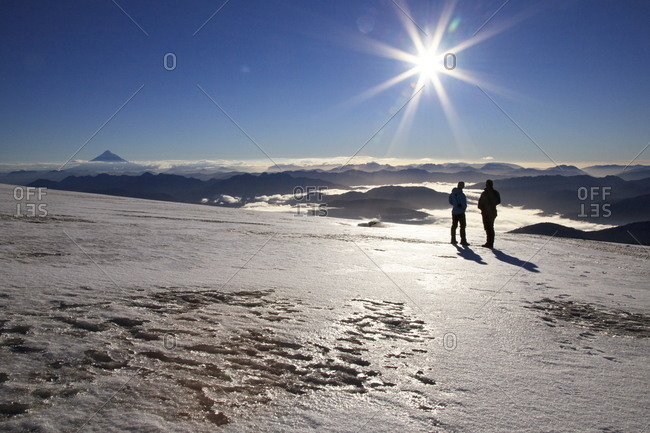 People watching a sunrise on a volcanic glacier, Huilo Huilo, Chile, South America