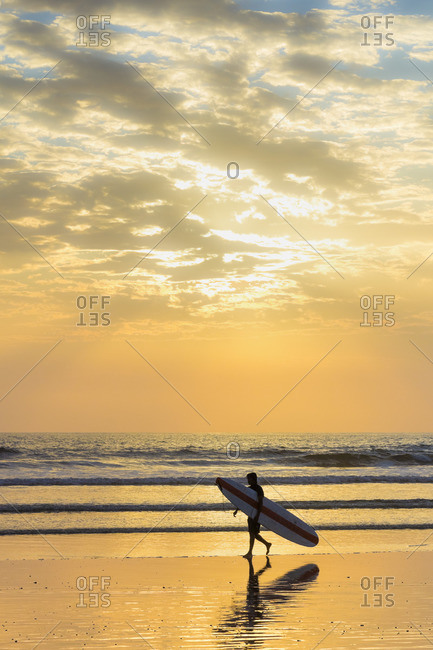 Surfer with long board at sunset, Playa Guiones surf beach, Nosara, Nicoya Peninsula, Guanacaste Province, Costa Rica, Central America