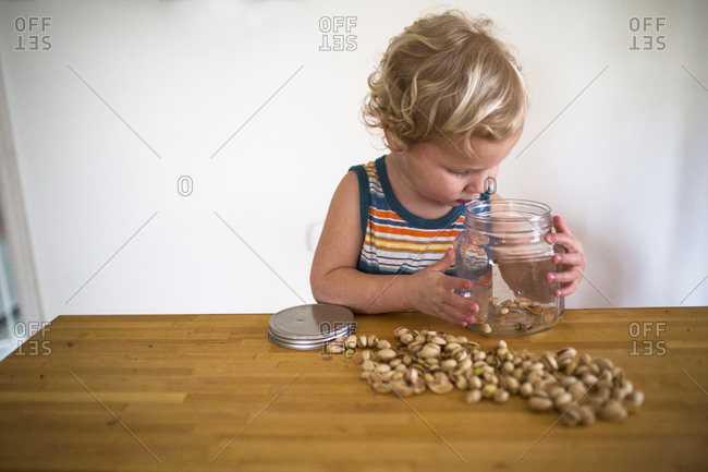 Boy looking at jar of pistachio shells