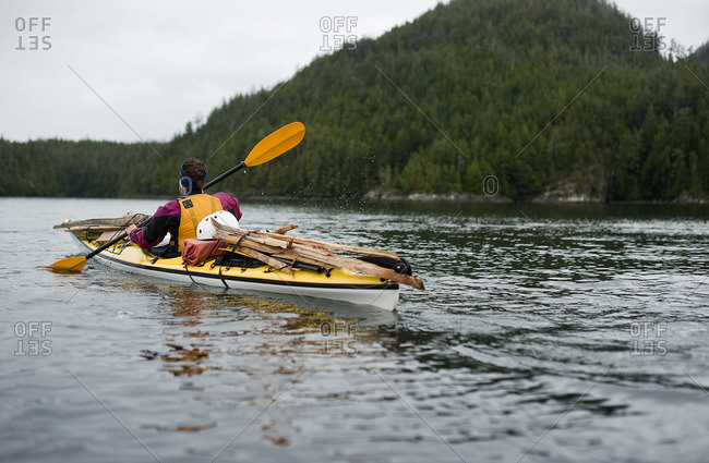 A girl paddles off in a sea kayak