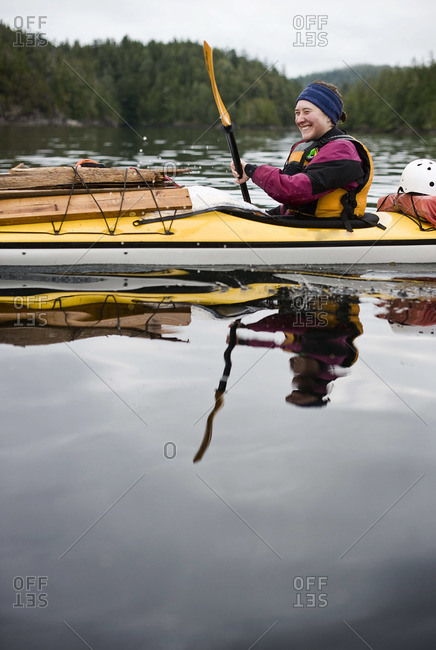 A girl laughs while she paddles a sea kayak