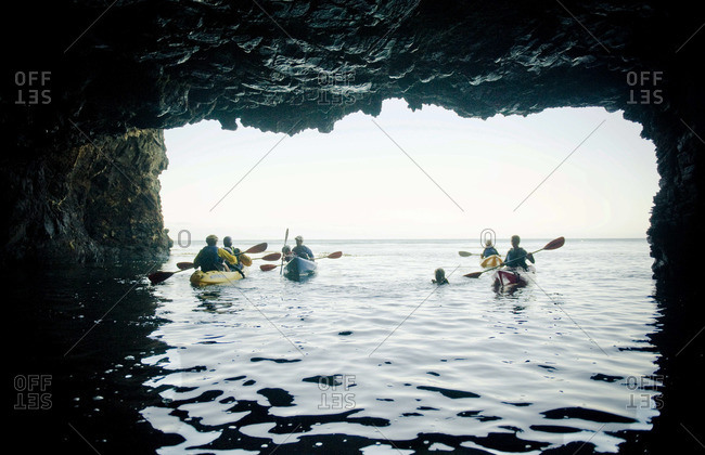 Exploring a large sea cave by kayak on Santa Cruz Island in the Channel Islands off Santa Barbara, CA.