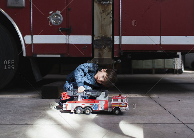 Boy playing with a toy fire truck