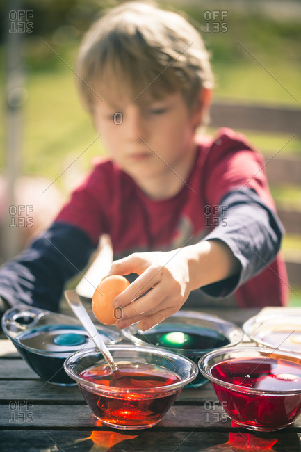 Boy dyeing Easter eggs