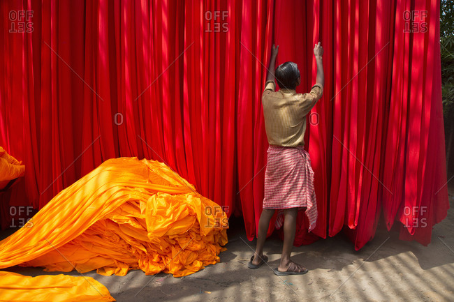 Worker adjusts drying dyed cloth