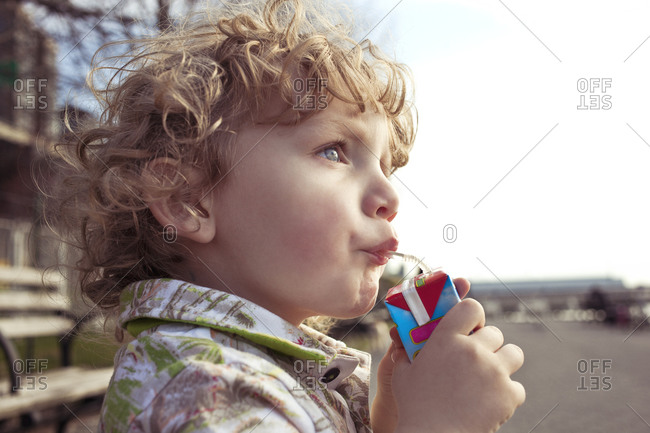 Little boy slurping on a juice box