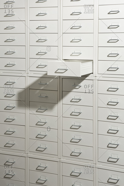 A white cabinet of drawers with one drawer open
