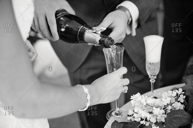 Groom pouring sparkling wine to bride\'s glass
