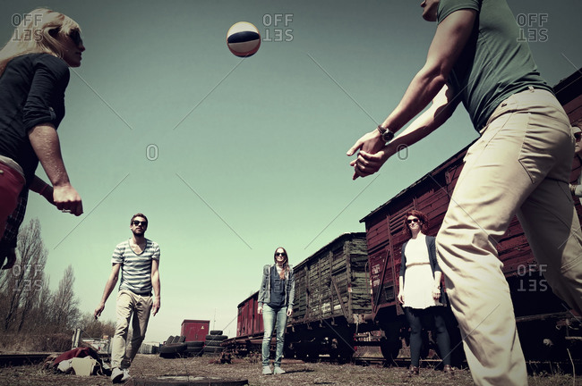 Group of five friends playing volley ball