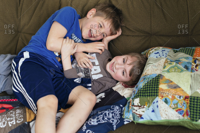 Two boys wrestling on couch