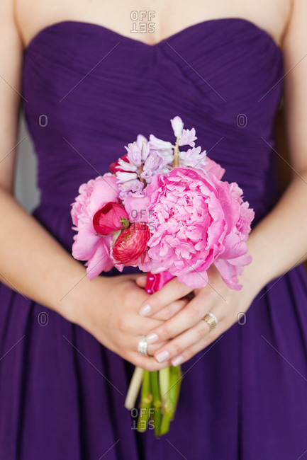 Mid section view of bridesmaid holding a bouquet