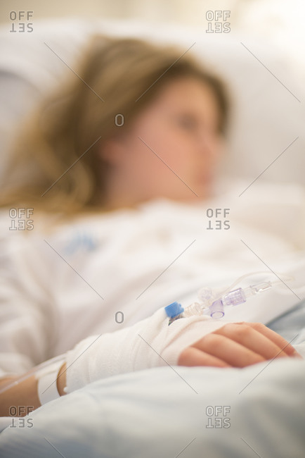 Girl with IV drip in hospital bed