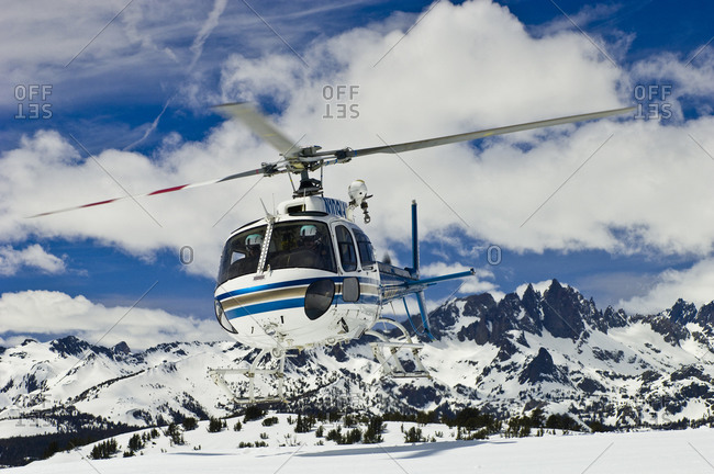 Helicopter taking off in snowy mountains