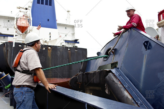 Crew members on a tugboat discuss strategy for transiting the Miraflores Locks on the Panama Canal