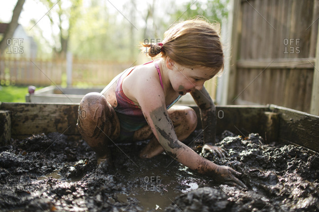 Redhead girl playing in mud