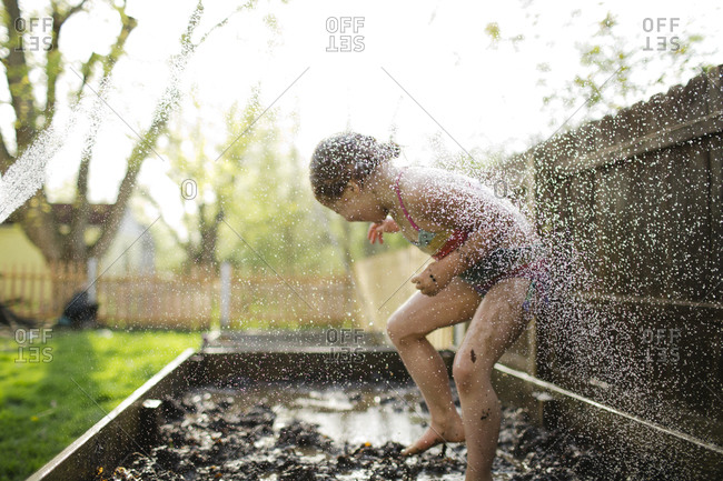 Young girl being splashed in mud box