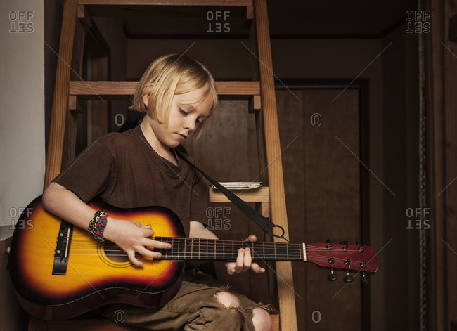 Boy playing an acoustic guitar