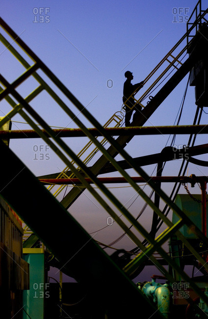 Silhouette of a man climbing up a drilling rig outside of Cairo, Egypt