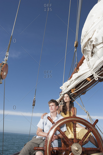 Couple at helm of sailboat