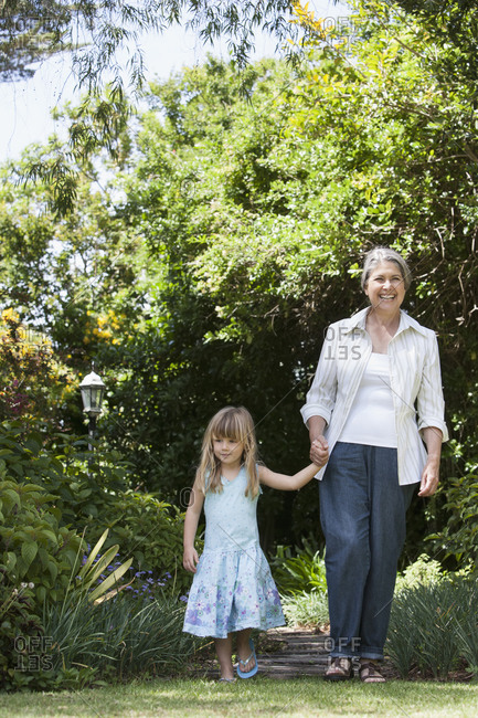 Grandmother and granddaughter walking in garden