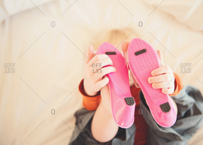 Girl touching pink shoes on her feet