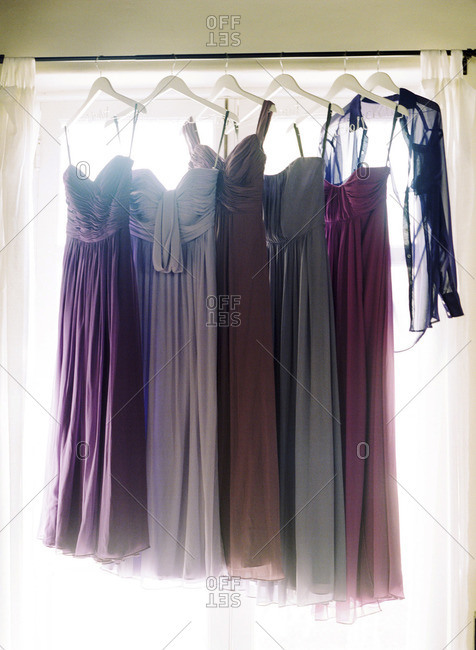 Bridesmaids\' dresses hanging by a window