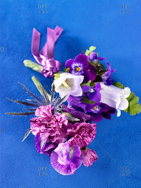 Purple and white boutonniere on blue suede