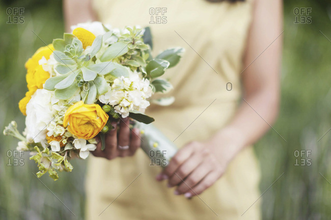 Mid section view of bridesmaid holding a bouquet