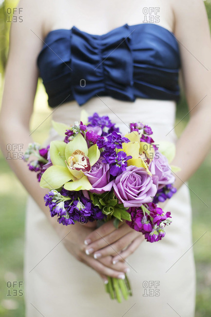 Mid section view of bride holding bridal bouquet