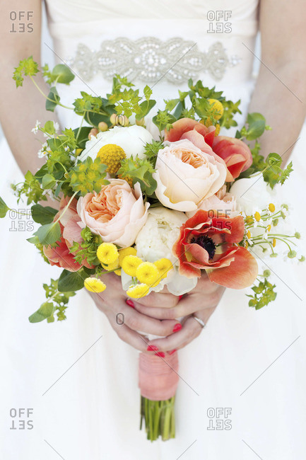 Mid section view of bride holding colorful bridal bouquet