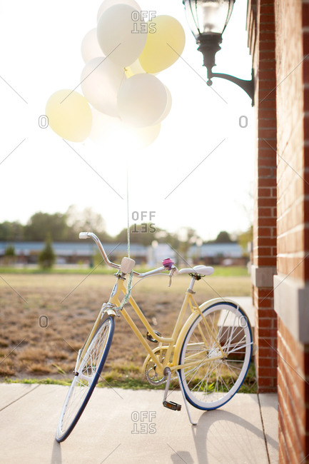 Yellow bicycle with balloons in a backyard