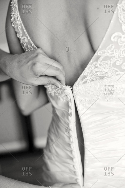 Woman zipping up a wedding dress