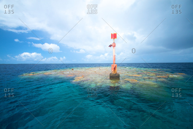 A channel marker sits atop a coral head and steers boaters away from the danger in Ahe atoll, Tuamotus.