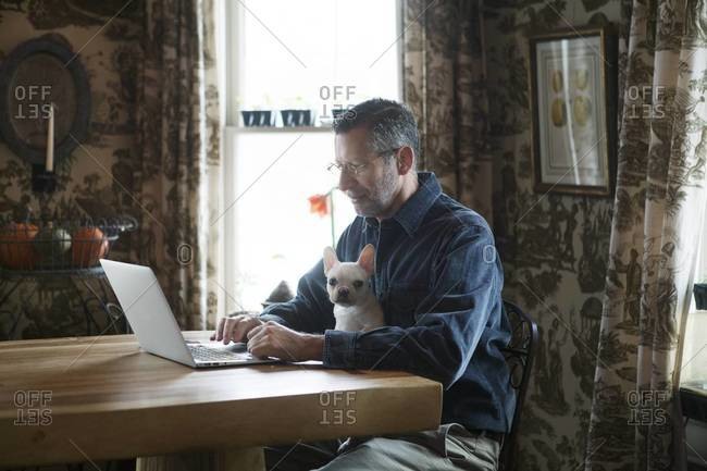 Middle-aged man with laptop and lapdog