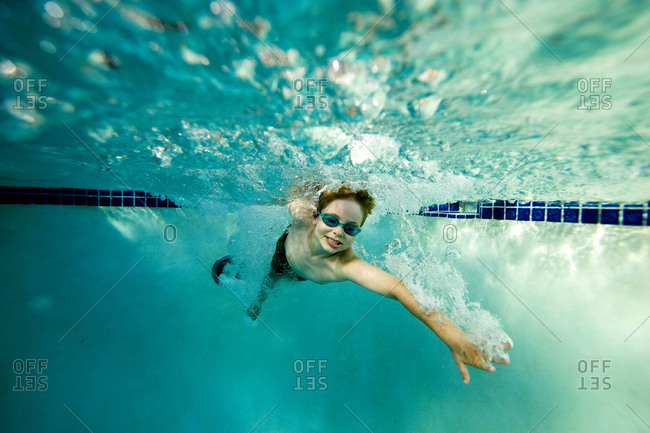 Seven year old boy swimming in a pool.