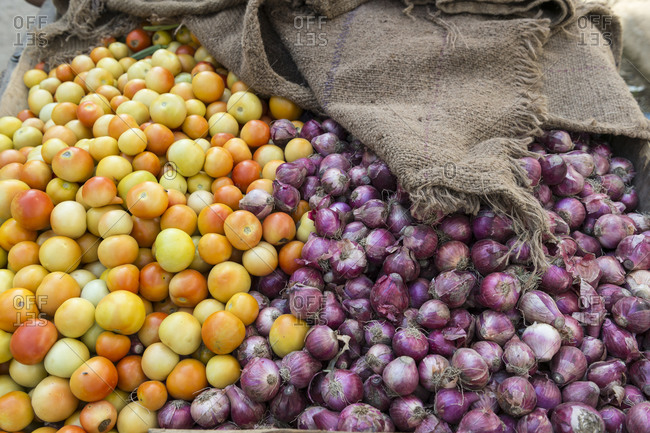 Heap of tomatoes and onions on a street vendor\'s cart in India