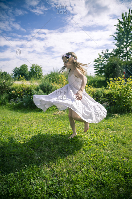 Girl in white summer dress on meadow